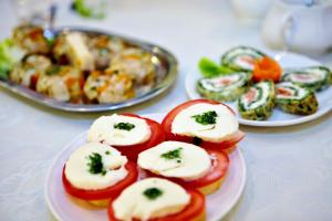 un plato de comida con tomates y queso. en Cyprianówka, en Warszowice