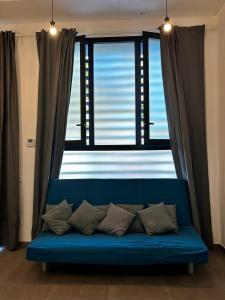 um sofá azul em frente a uma grande janela em Loft familiar "PISCINA SEVILLA CENTRO" em Sevilha