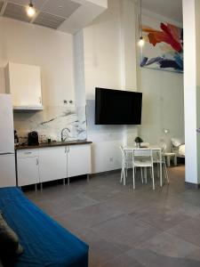 uma cozinha com uma mesa e uma televisão na parede em Loft familiar "PISCINA SEVILLA CENTRO" em Sevilha