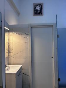 uma casa de banho com uma porta branca e um lavatório em Loft familiar "PISCINA SEVILLA CENTRO" em Sevilha