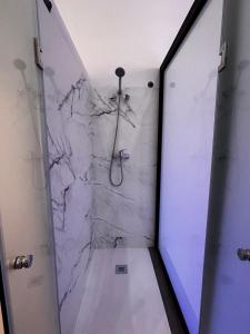 uma casa de banho com uma cabina de duche em mármore e um chuveiro. em Loft familiar "PISCINA SEVILLA CENTRO" em Sevilha