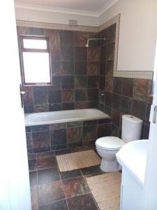 y baño con bañera, aseo y lavamanos. en Charming Studio in Stellenbosch - The Valley Stay, en Stellenbosch