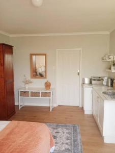 Habitación con cocina con cama y espejo. en Charming Studio in Stellenbosch - The Valley Stay, en Stellenbosch