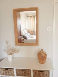 a mirror on a wall above a counter in a room at Charming Studio in Stellenbosch - The Valley Stay in Stellenbosch