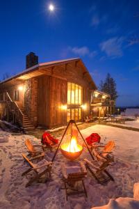 a log cabin with chairs and a fire in the snow at Seesaw's Lodge in Peru