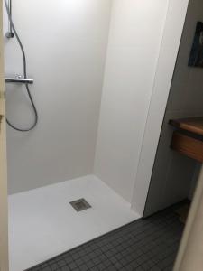 a shower in a bathroom with a white wall at maison bleue in Biscarrosse +10 photos