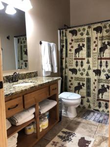 un bagno con lavandino, water e tenda da doccia di Yellowstone Park, Hot Tub a Island Park