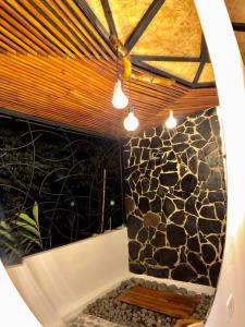 a bathroom with a stone wall and a shower with lights at Ecofuratena Glamping & Experience in Utica