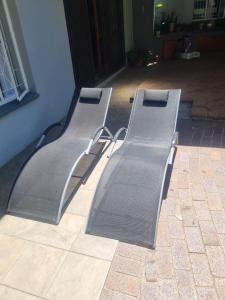 two metal benches sitting next to a building at Bella on St James in Johannesburg