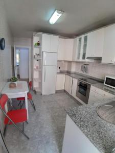 una cucina con un tavolo e un frigorifero bianco di Apartamento Obispo Frutos a Murcia