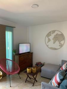 uma sala de estar com um sofá e uma televisão de ecrã plano em Marea La Caleta El Hierro em La Caleta