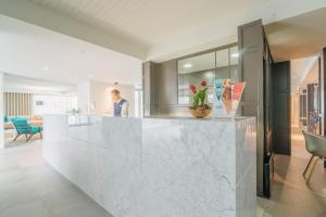 a lobby with a white marble counter and a person at Aqualuz Lagos by The Editory in Lagos +37 photos