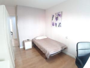 una piccola camera da letto con un letto e una sedia di Apartamento Obispo Frutos a Murcia Altre 35 foto