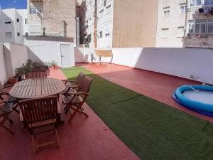 un patio con tavolo e sedie e una piscina di Apartamento Obispo Frutos a Murcia