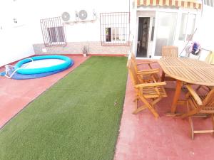 un patio con un tavolo e una tavola da surf blu sopra di Apartamento Obispo Frutos a Murcia