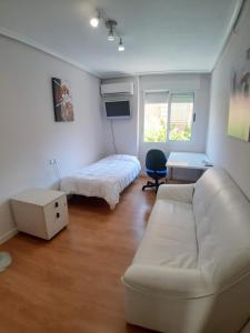 un soggiorno con un divano e un letto di Apartamento Obispo Frutos a Murcia