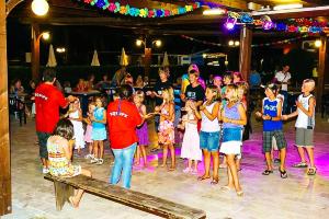 a group of children on the dance floor at a party at Chalet Grand Charme voor 4 personen op Camping River Village - JoyCasa in Ameglia