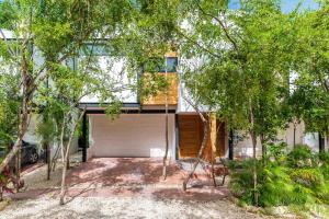 a garage in front of a house with trees at Spacious 3BR Close to Tulum Ruins, Beach & Town in Tulum