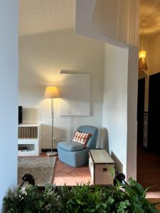 a living room with a blue chair and a lamp at Valentine's House in Óbidos