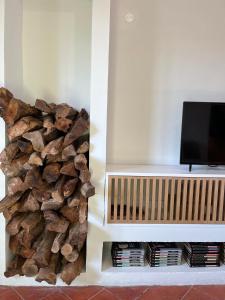 a pile of fire wood next to a tv at Valentine's House in Óbidos