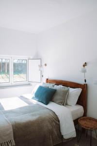 - une chambre avec un grand lit et un oreiller bleu dans l'établissement Just Like Home - Casa Antonio em Paredes de Coura, à Paredes de Coura