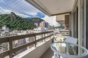 a balcony with a chair and a view of a city at Conforto em Copacabana - 1 quarto - BR1307 Z3 in Rio de Janeiro