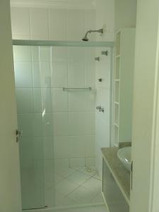 baño blanco con ducha y lavamanos en Linda casa com piscina e 4 suites no mariscal a 100 metros da praia, en Bombinhas