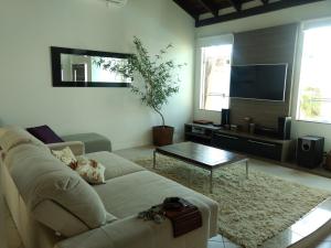 sala de estar con sofá y TV en Linda casa com piscina e 4 suites no mariscal a 100 metros da praia, en Bombinhas
