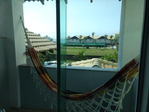 un balcón con hamaca y vistas a un patio en Linda casa com piscina e 4 suites no mariscal a 100 metros da praia, en Bombinhas