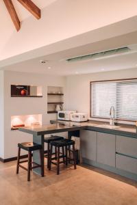 a kitchen with a counter and stools in a room at Juwoldam in Jeju