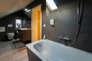 a bathroom with a white tub and a sink at Bördeapartment am Heiderand 