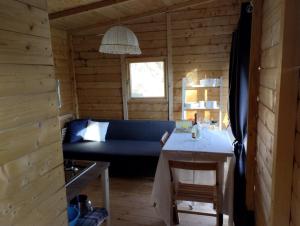 a living room with a blue couch in a log cabin at Agricampeggio la casa di Nicla in Cavriglia