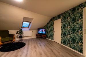 a living room with green walls and a television at Bördeapartment am Heiderand 
