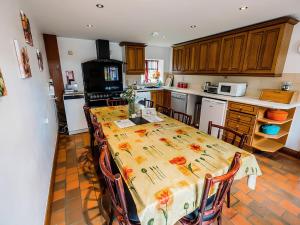 a kitchen with a table with chairs and a kitchen with a stove at Elm Cottage - Rchp133 in Calton