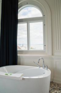 y baño con bañera y ventana. en Les Lofts du Trésor - Par Les Lofts Vieux-Québec, en Quebec