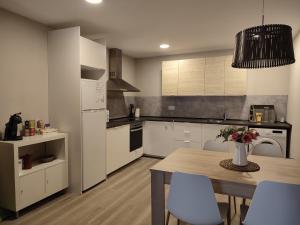 a kitchen with white cabinets and a table with chairs at Can Costals Olivo in Pals