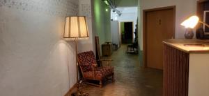 une chambre avec une lampe et une chaise dans un couloir dans l'établissement Hostel Très Schick, à Bamberg