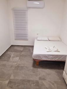 a bedroom with a bed with two white shoes on it at דירה בסטייל in Eilat