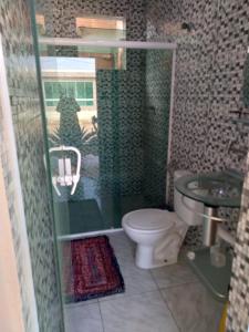 y baño con ducha, aseo y lavamanos. en Casa Pé na Areia Monte Alto Arraial do Cabo RJ en Arraial do Cabo