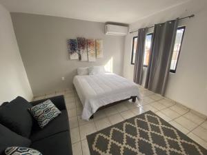 トゥストラ・グティエレスにあるDepartamento Cumbresのベッドルーム1室(ベッド1台、ソファ、ラグ付)