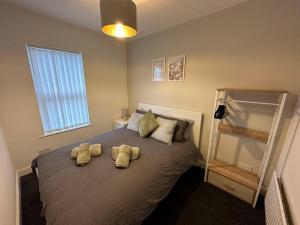 een slaapkamer met een bed met twee gele handdoeken erop bij MMC Serviced accommodation in Leigh