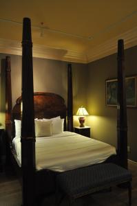 a bedroom with a large bed with white sheets and pillows at The Inn at Houmas House Estate in Darrow