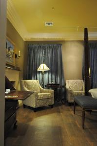 sala de estar con sillas, mesa y lámpara en The Inn at Houmas House Estate, en Darrow