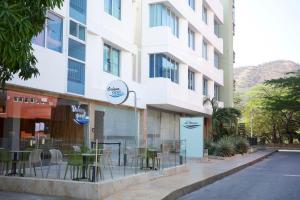 a building with tables and chairs outside of it at Hotel La Riviera in Santa Marta