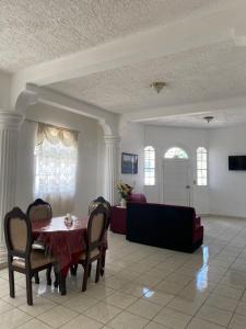- une salle à manger avec une table et un canapé dans l'établissement Casa en el Centro de Ilobasco, à Nanastepeque