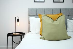 - un lit avec un oreiller et une lampe dans l'établissement No1 Under the Clock by SSW - Cardiff City Centre, à Cardiff