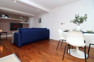 a living room with a blue couch and a table at Stylish City Apt, Balcony Near Stadium & Station in Cardiff