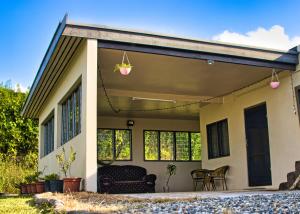 ein kleines Haus mit einer Terrasse in der Unterkunft Guddy’s Riverside Cottage in Nausori