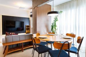 a dining room with a table and chairs and a couch at Apto com máquina de lavar perto do metrô Trianon in Sao Paulo