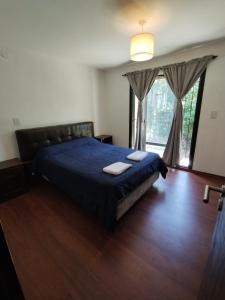 1 dormitorio con 1 cama con 2 toallas en Hermoso Chalet en zona privilegiada de Villa Giardino en Villa Giardino